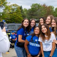 Attendee takes a picture of group of people during Family Day tailgate.
